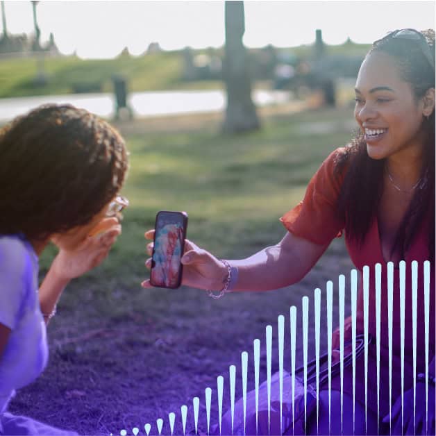 Two girls looking at a smartphone and smiling