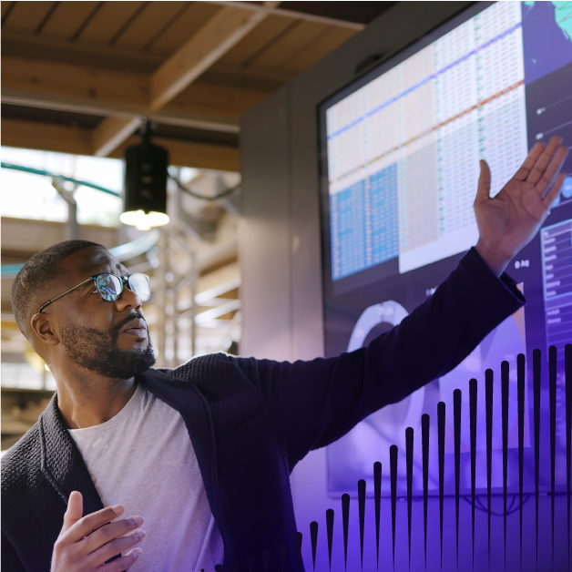 Man in glasses gesturing to a smart board