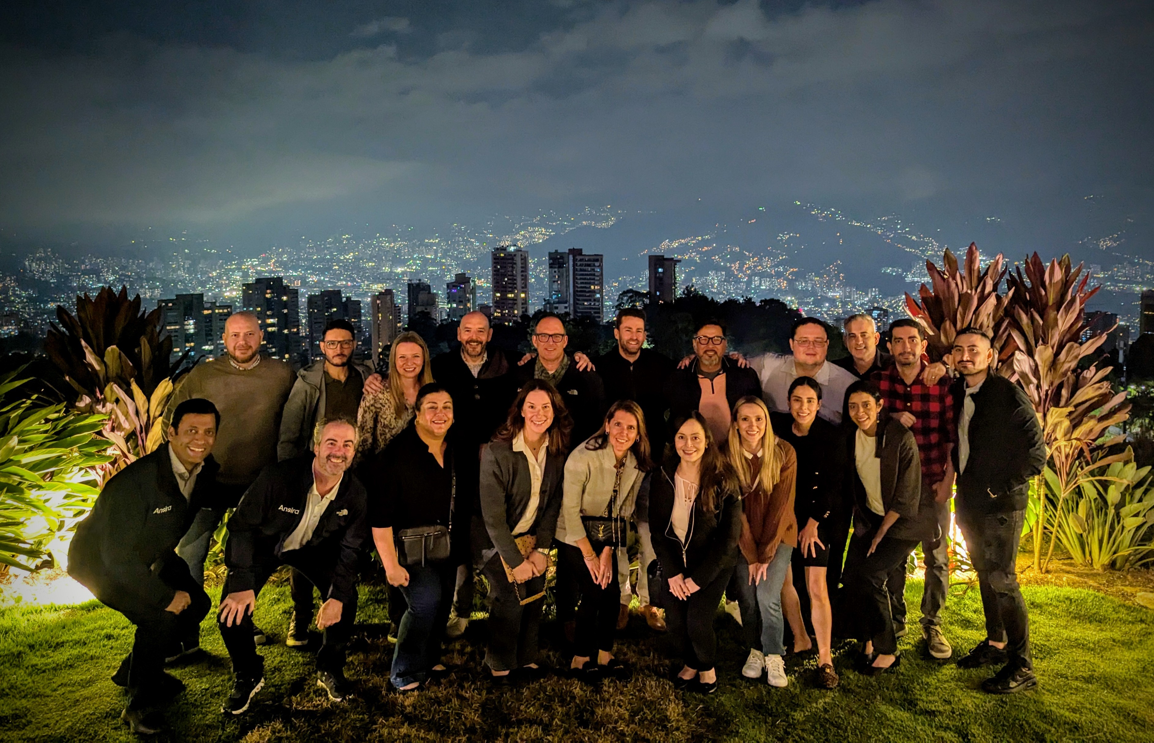 Group photo taken in front of skyline at night in Colombia