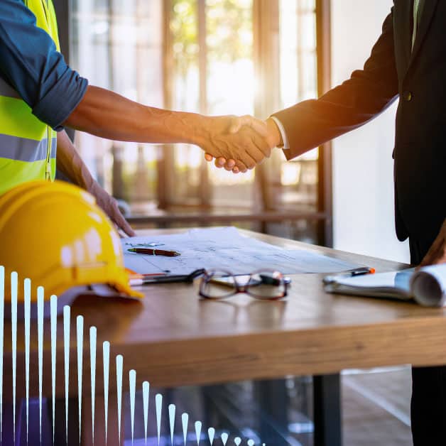 A man in a construction vest shaking hands with a man in a suit